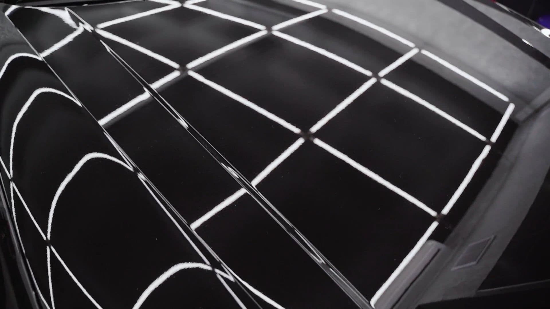 Studio light strips reflected in freshly polished black paint